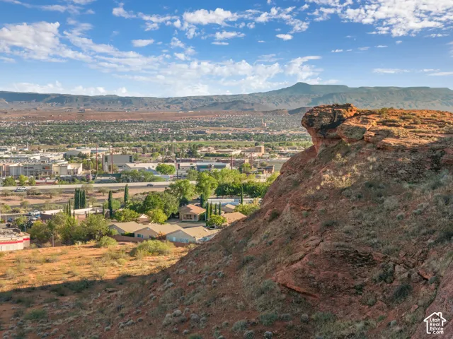 Expansive aerial of a developed community with surrounding natural rock formations and distant mountains