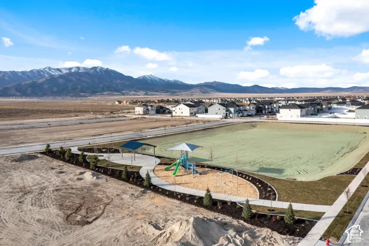 Community park area featuring a playground, two covered shelters, and a large open field