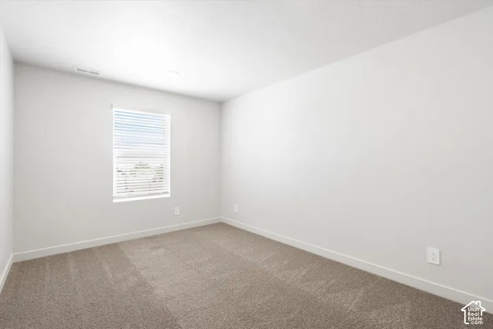 **DICSLAIMER** Interior package may vary.  Neutral color palette with light gray walls, textured carpeting, and a window with horizontal blinds