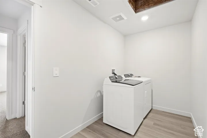 **DICSLAIMER** Interior package may vary.  Laundry area featuring wood-finish flooring, white walls, and a recessed ceiling light