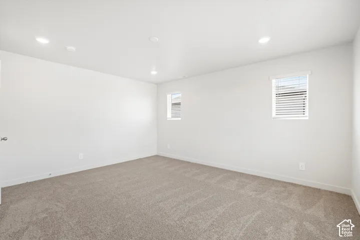 **DICSLAIMER** Interior package may vary.  Plush carpet flooring with white wall finishes, recessed lighting, and two windows featuring horizontal blinds
