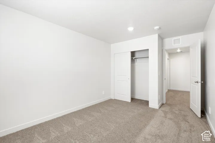 **DICSLAIMER** Interior package may vary.  Neutral carpet flooring, white walls, recessed ceiling lighting, and a sliding door closet with built-in shelving and hanging rod