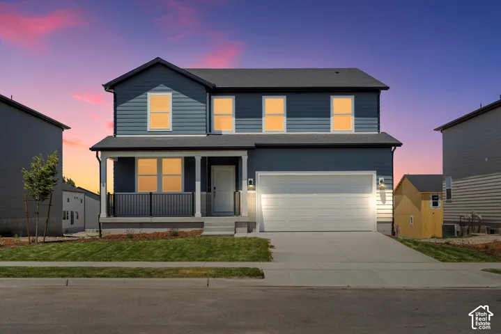 Two-story residence featuring a two-car garage, covered front porch, and a storage shed