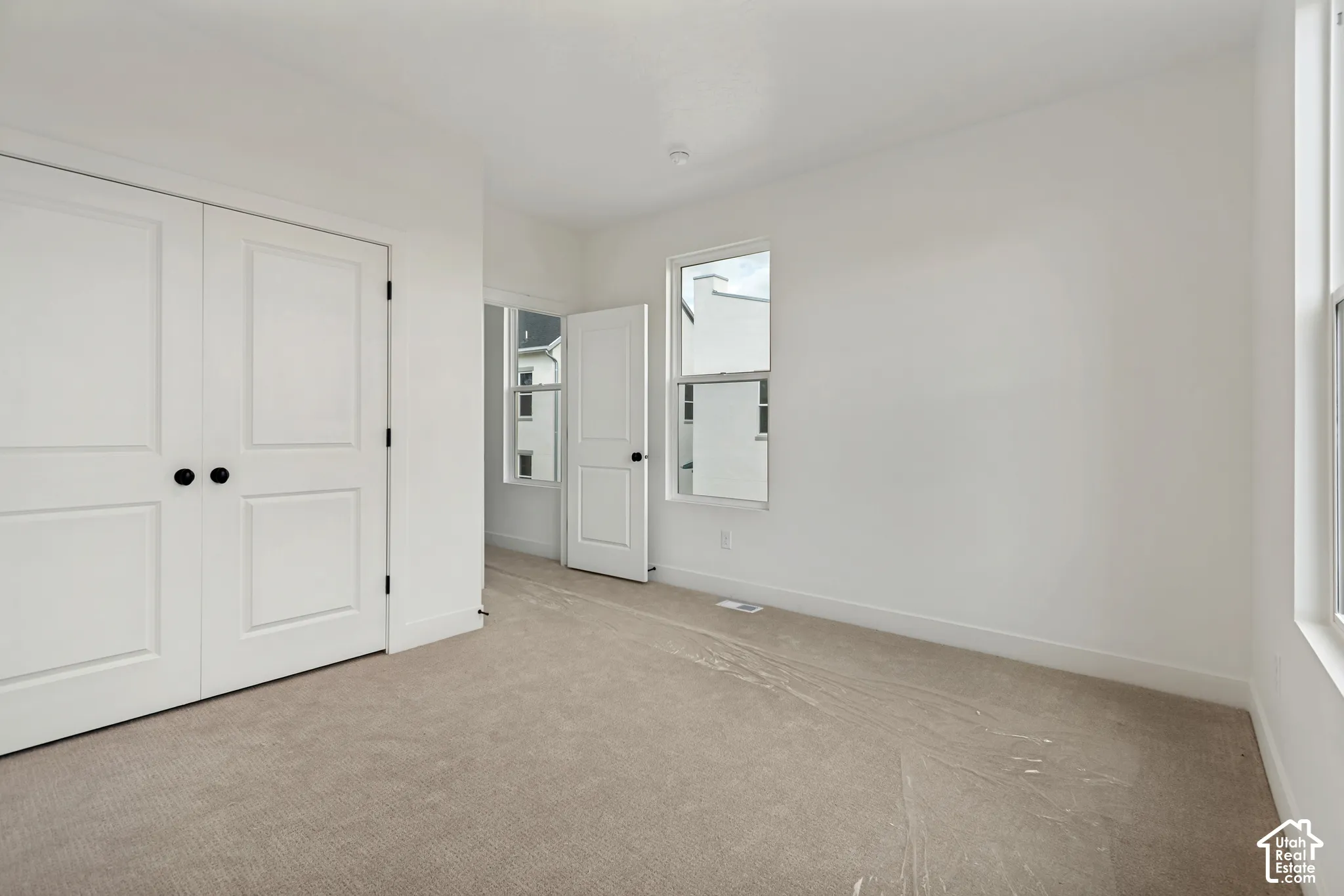 Neutral-toned carpeting, white walls, and white trim