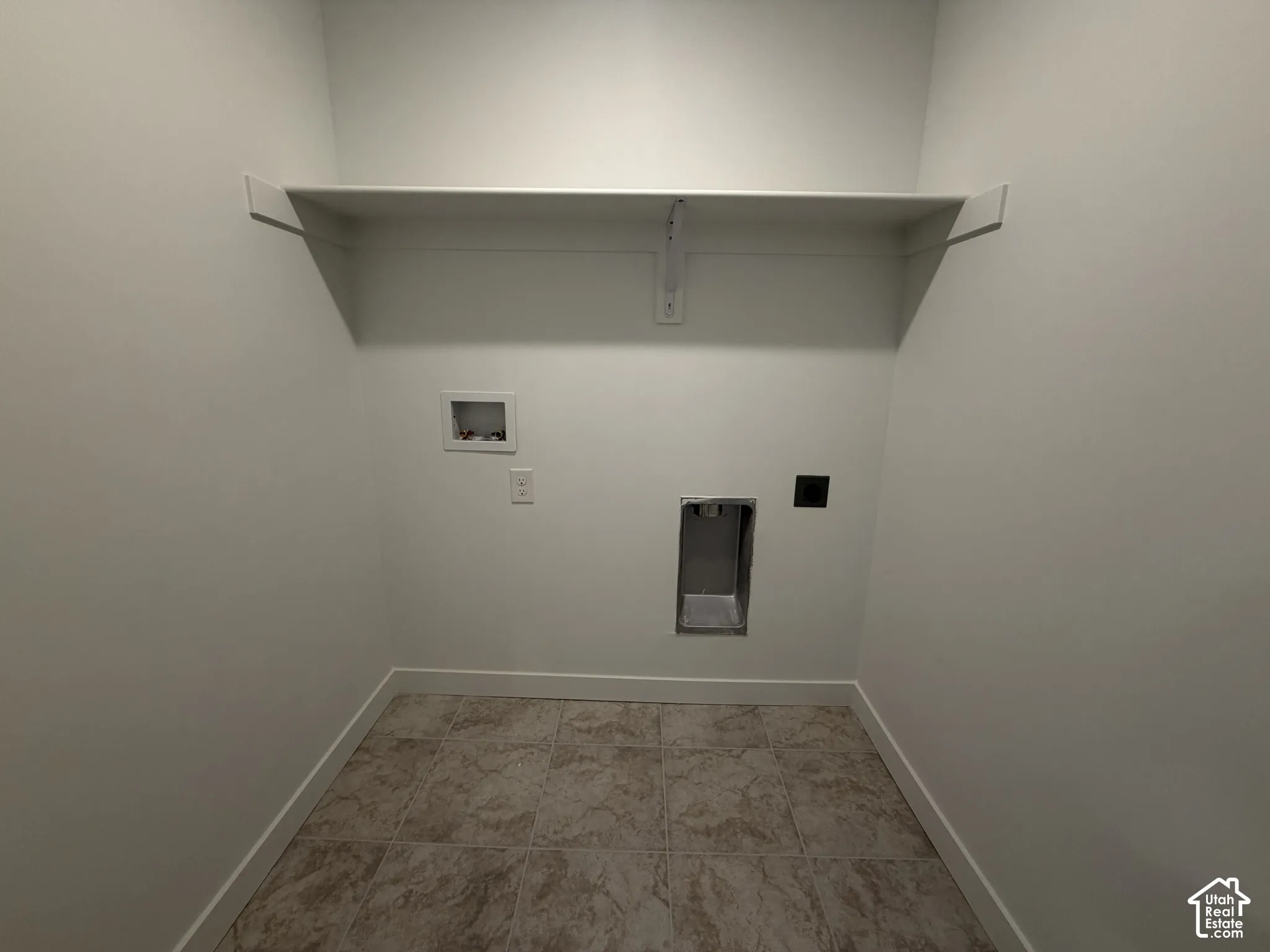 Built-in shelving, tile flooring, and utility hookups