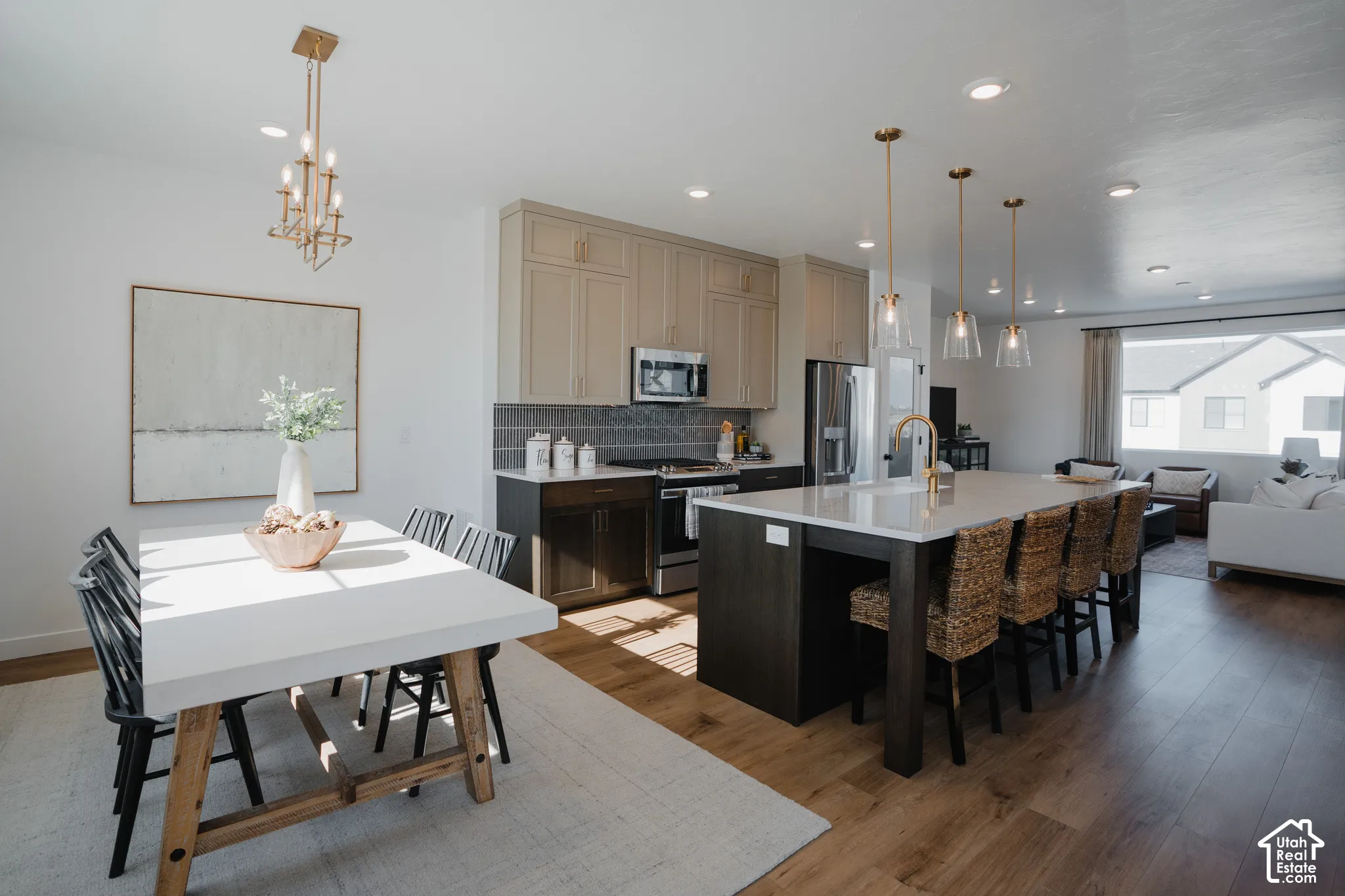 Open-concept floor plan featuring wood-finish flooring, a kitchen island with seating, pendant lighting, and recessed lighting