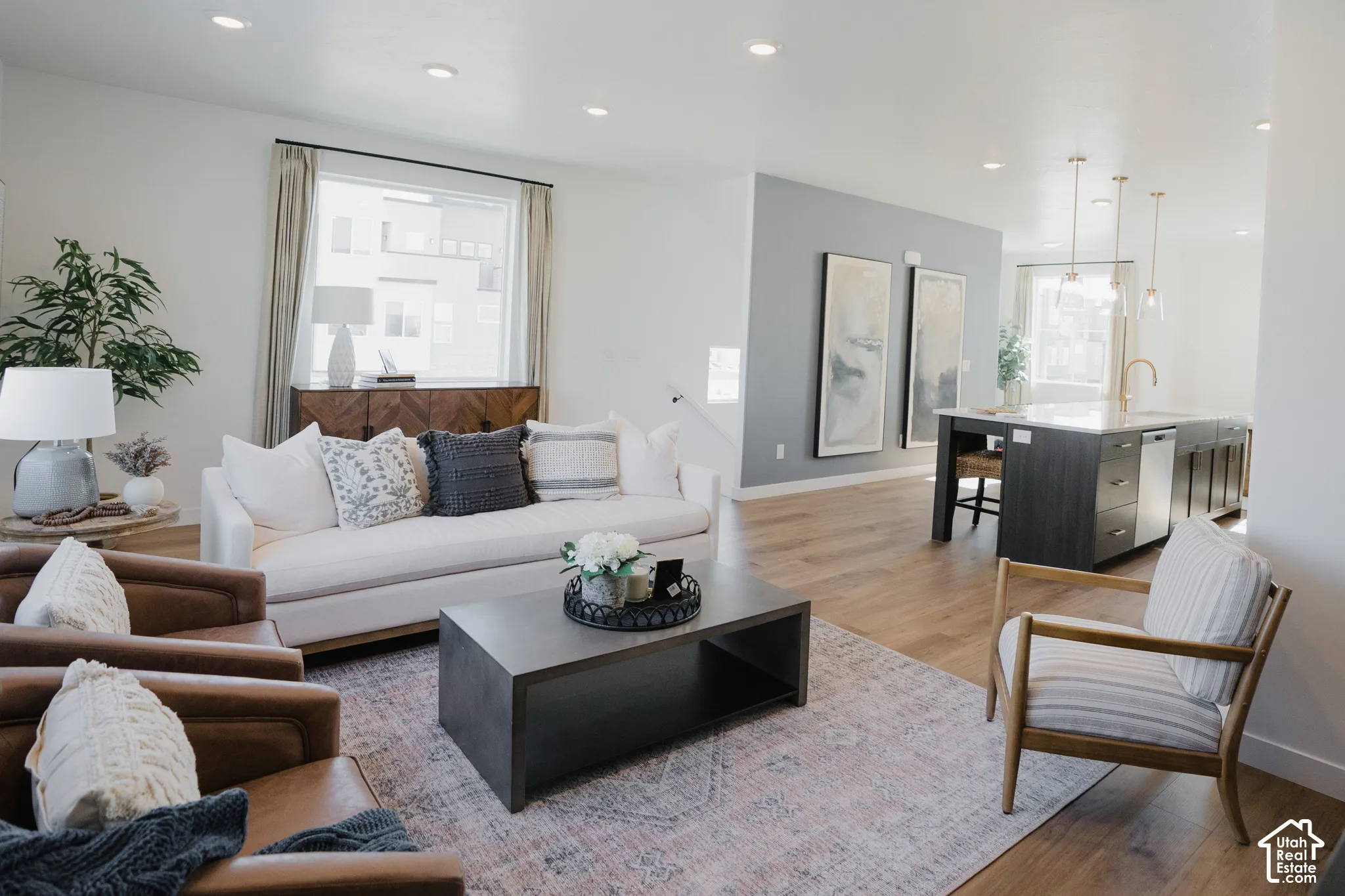 Bright living area with recessed lighting, wood-finish flooring, and a large window