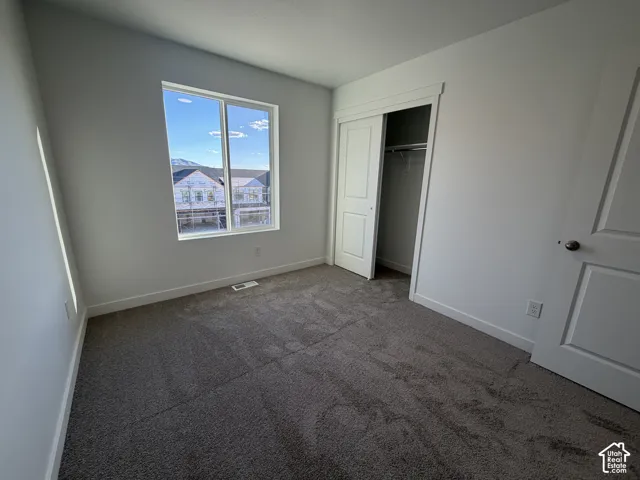 Neutral-toned carpeting, white walls, and a large window