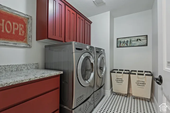 Laundry room featuring rich red cabinetry, a speckled countertop, and black and white patterned floor tiles