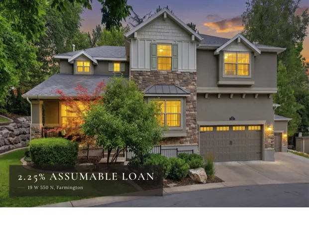 Stucco and stone facade with board-and-batten accents, dormer windows, and an integrated two-car garage