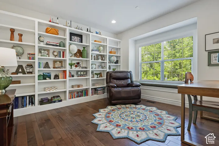 Built-in shelving, recessed lighting, wood-finish flooring, a window seat, and window blinds