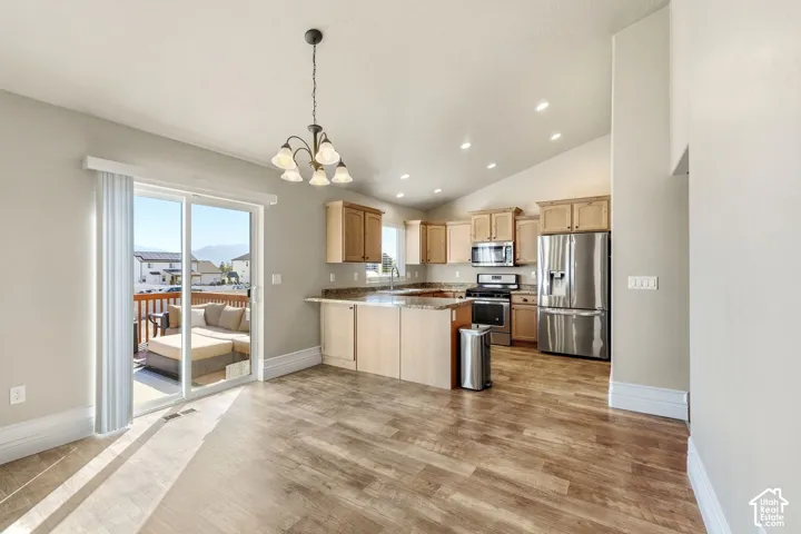 Open-concept living space featuring wood-finish flooring, recessed lighting, and a vaulted ceiling