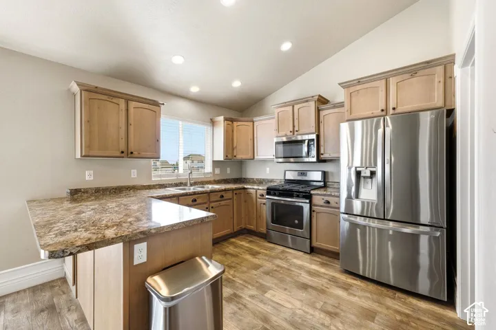 Spacious kitchen featuring warm wood cabinetry, granite countertops, and a large center island with seating