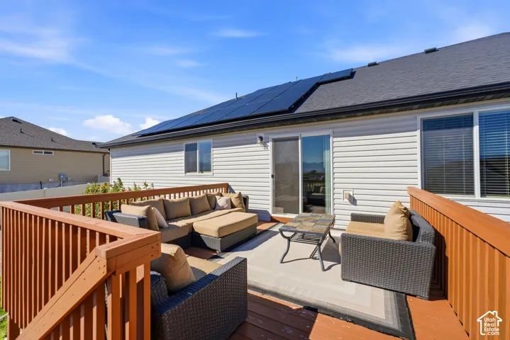 Expansive outdoor deck with wood railing, leading to a sliding glass door
