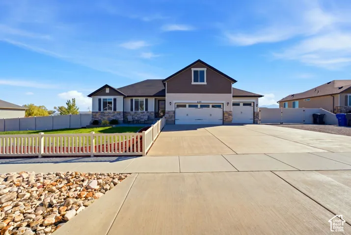 Contemporary exterior with stone accent, a two-car garage, and an additional single-car garage