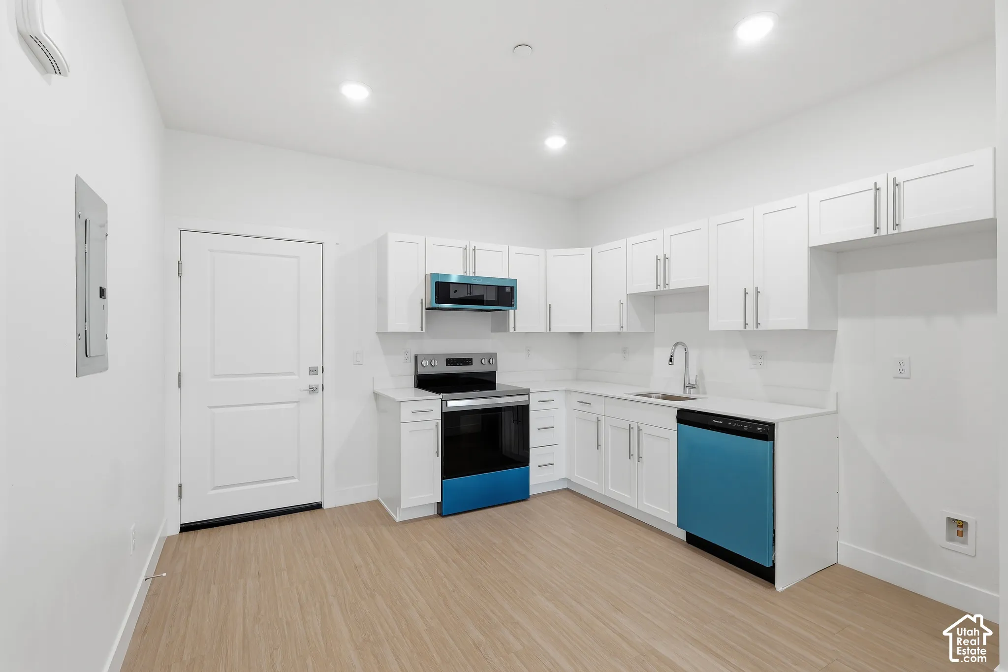 Kitchen featuring white shaker cabinetry, light-toned wood-finish flooring, recessed lighting, and a full suite of stainless steel appliances