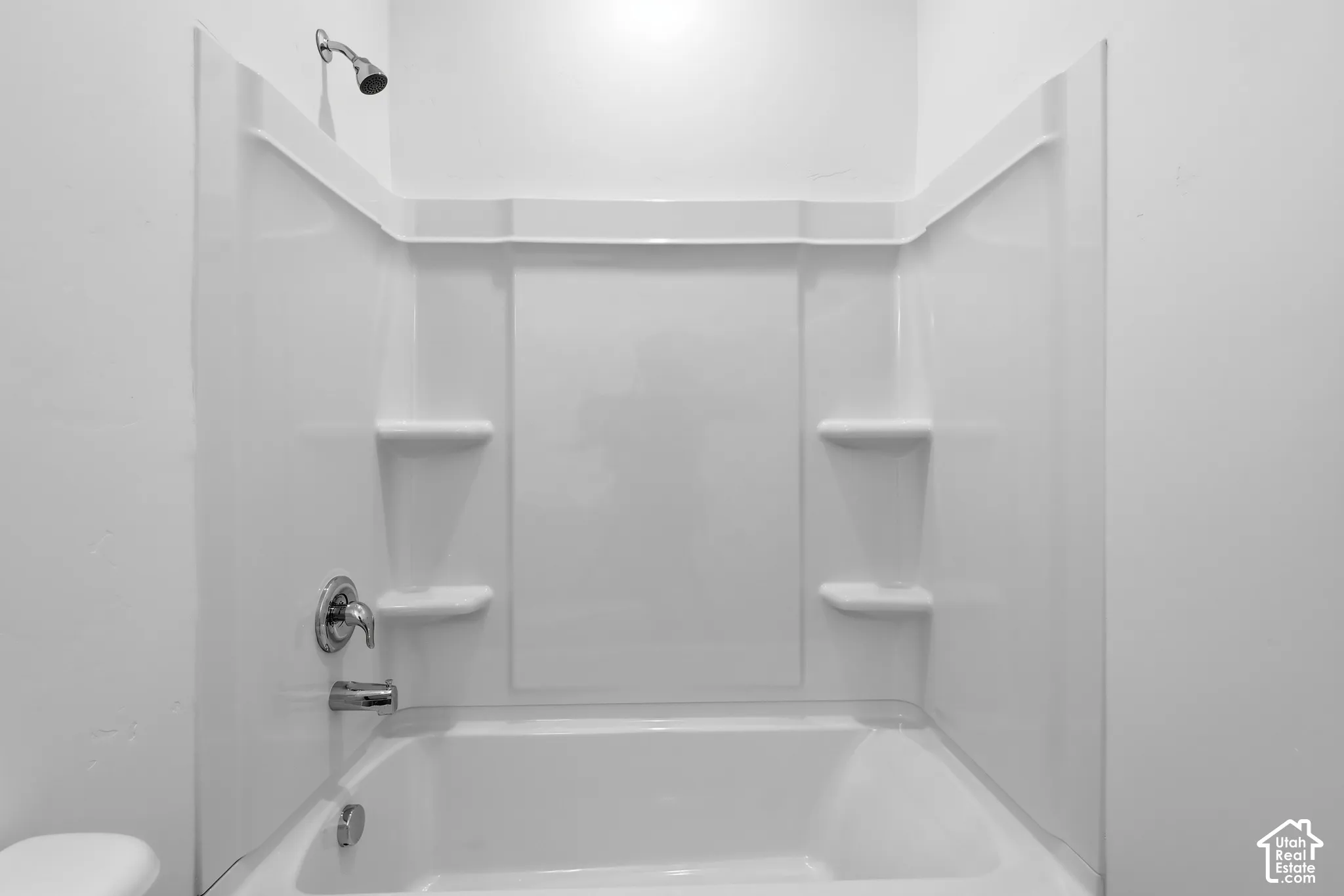 White tub and shower combination with chrome fixtures