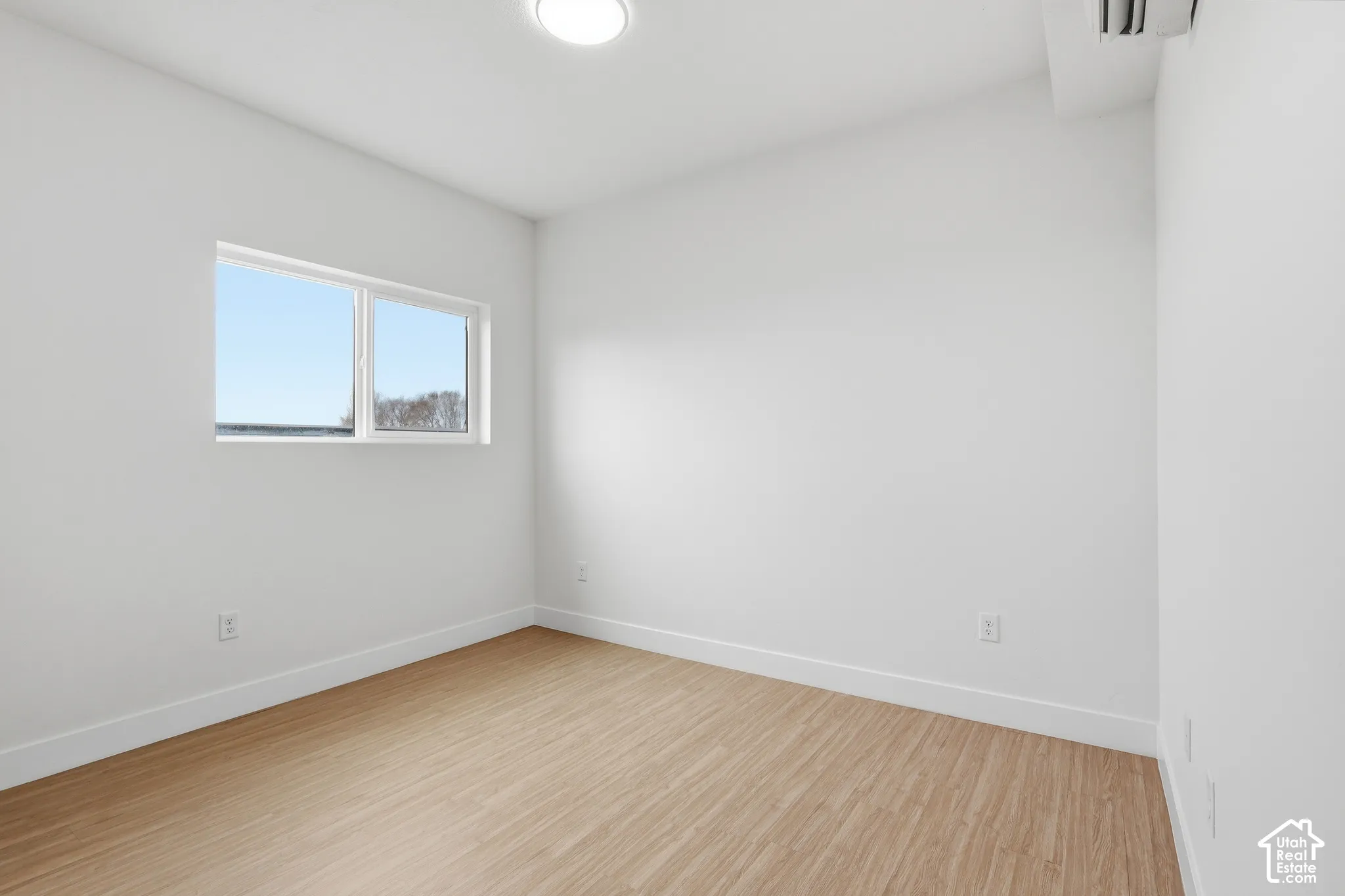 Recessed lighting, wood-finish flooring, and white walls