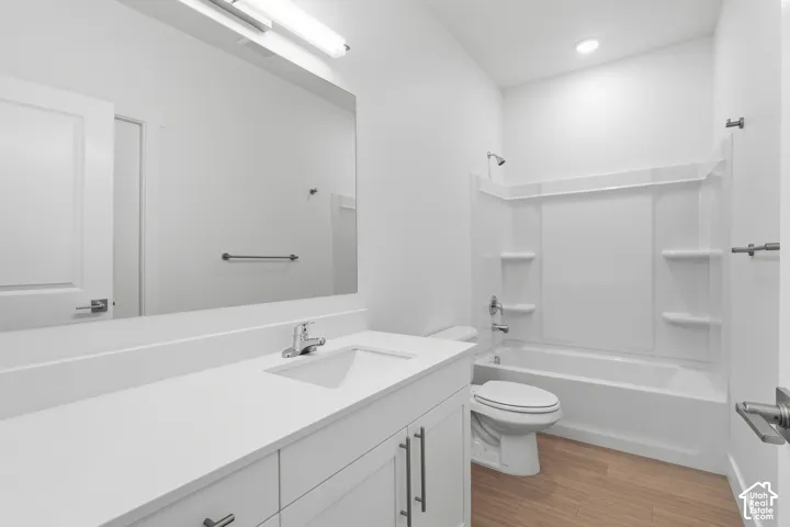 White vanity with a single basin sink, chrome faucet, and expansive mirror