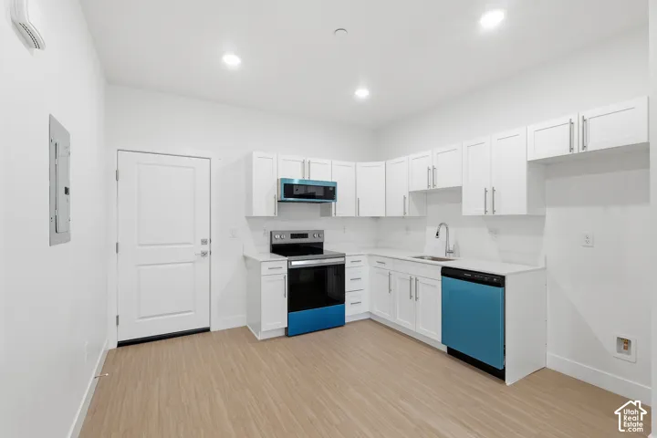 Kitchen featuring white shaker cabinetry, light-toned wood-finish flooring, recessed lighting, and a full suite of stainless steel appliances