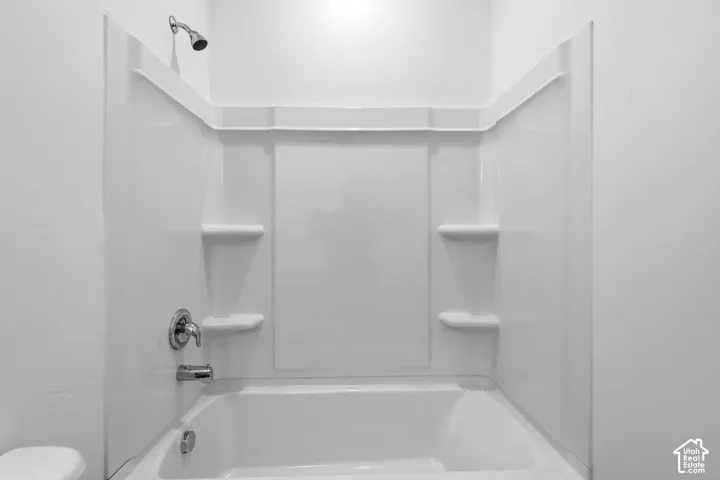 White tub and shower combination with chrome fixtures
