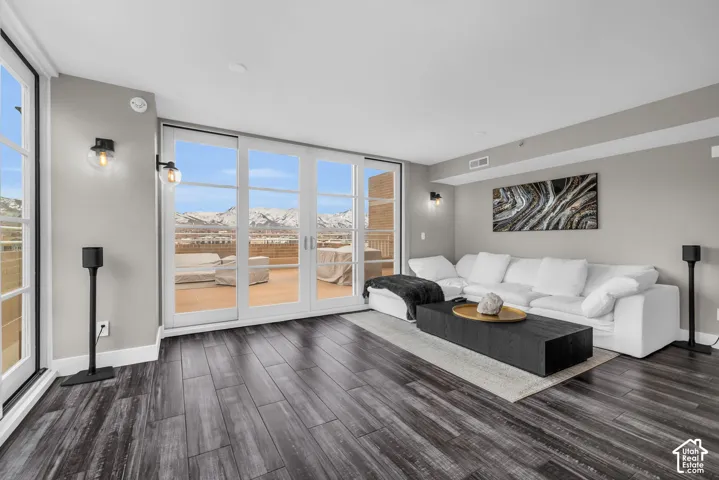 Wood-finish flooring throughout, light gray wall color, and multiple sets of glass panel doors