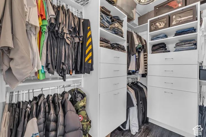 Custom closet system featuring multiple hanging rods, integrated drawer storage, and open shelving