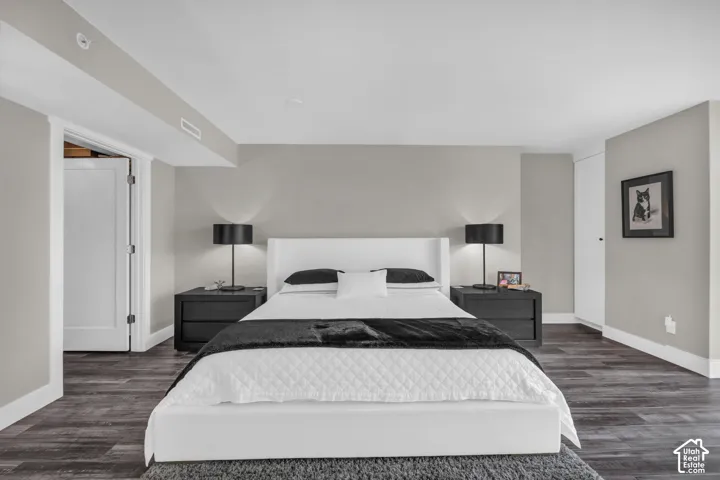 Recessed lighting, wood-finish flooring, light gray wall tones, built-in storage, and a paneled white door
