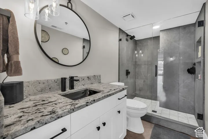 White vanity with a stone countertop, under-mount sink, and matte black fixtures