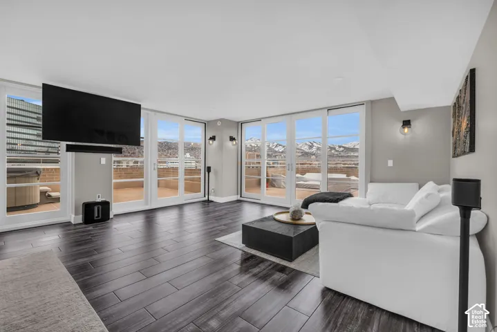 Wood-finish flooring, white French doors, recessed lighting, and wall-mounted sconces