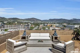 Rooftop patio with brick privacy wall, open-air setting, and prominent mountain backdrop