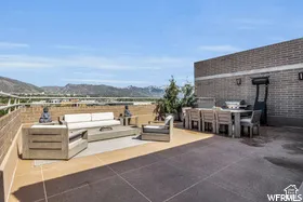 Rooftop patio with brick wall and mountain scenery