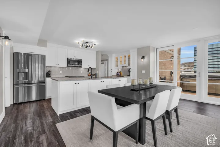 Modern kitchen featuring white cabinetry, stainless steel appliances, and a central island with a stone countertop