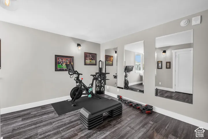 Light gray painted walls, wood-finish flooring, recessed lighting, and wall-mounted sconces