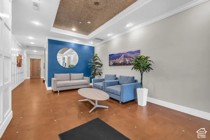 Recessed lighting, crown molding, white board and batten paneling, blue accent wall, and wood-finish flooring