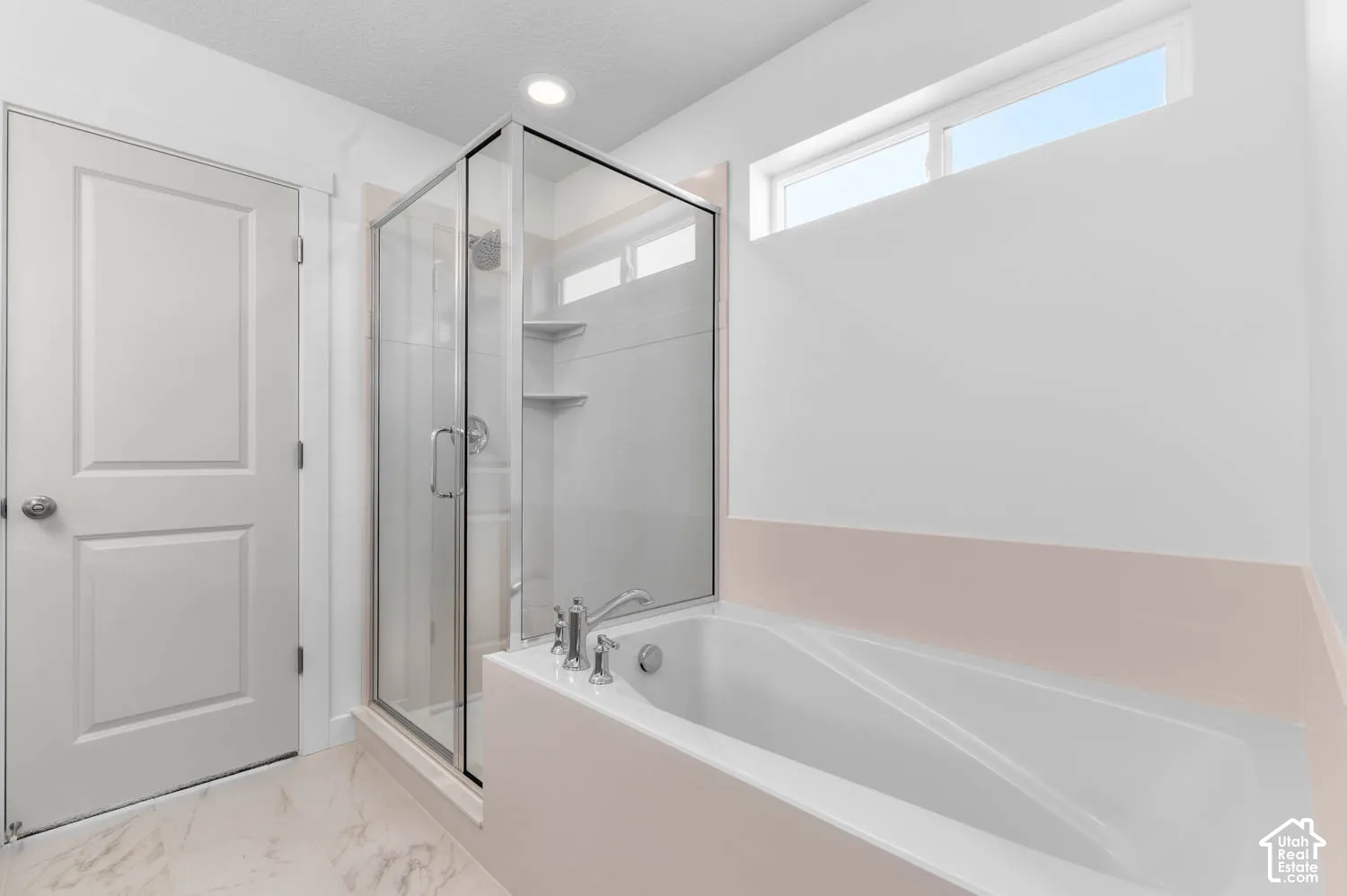 Walk-in shower with glass enclosure, built-in shelving, and a rain showerhead