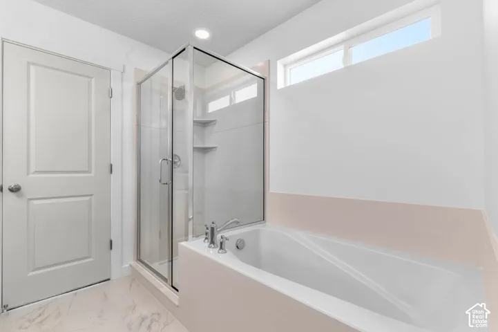 Walk-in shower with glass enclosure, built-in shelving, and a rain showerhead