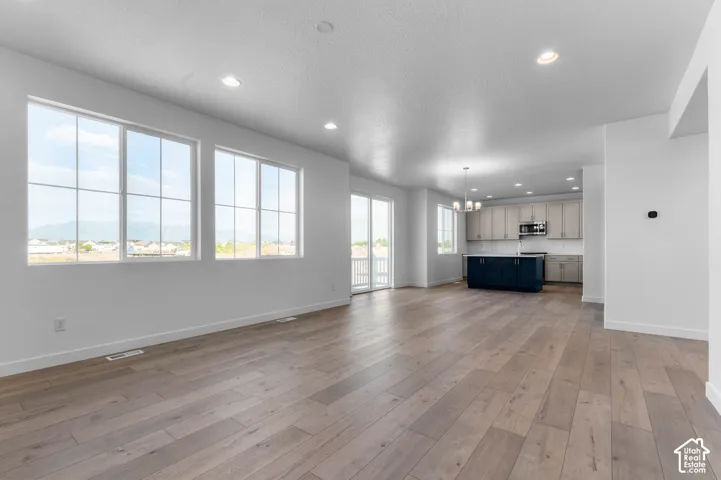 Spacious living area with wood-finish flooring, recessed lighting, and large grid-paned windows