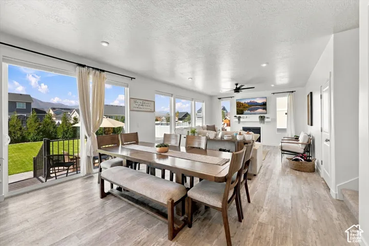 Open-concept living area with wood-finish flooring, recessed lighting, and a ceiling fan
