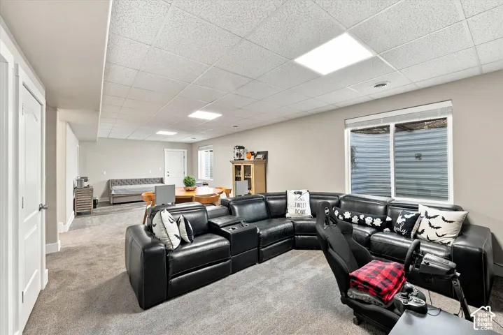 Open-concept room with neutral wall tones, recessed lighting, and light-colored carpeting