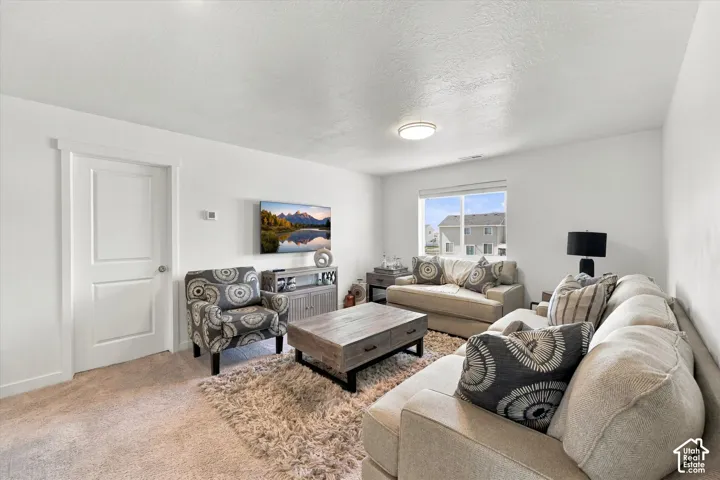 Neutral wall color, carpeted flooring, recessed lighting, white trim, and a window with a neighborhood backdrop