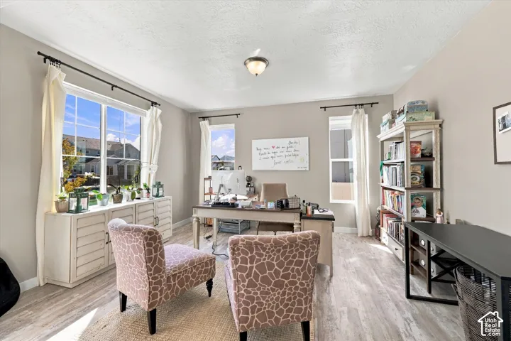 Spacious room with multiple windows, recessed lighting, and light wood-finish flooring