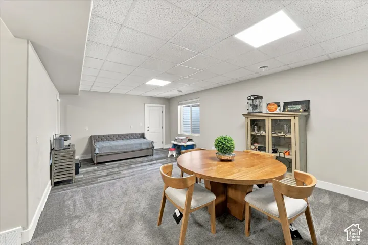 Two-tone flooring, recessed lighting, and a window with blinds