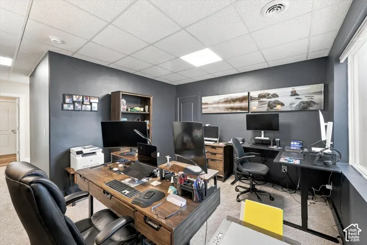Office space featuring dark walls, carpet flooring, a window, and recessed lighting