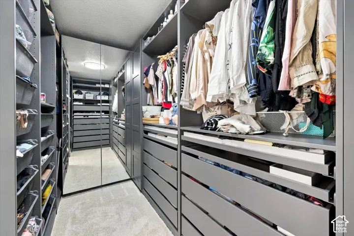 Custom built-in closet system with extensive shelving, multiple drawer units, hanging rods, and integrated full-length mirrors