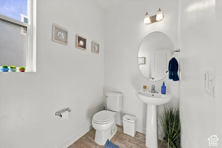 Pedestal sink with chrome faucet, oval mirror, and wall-mounted vanity lighting
