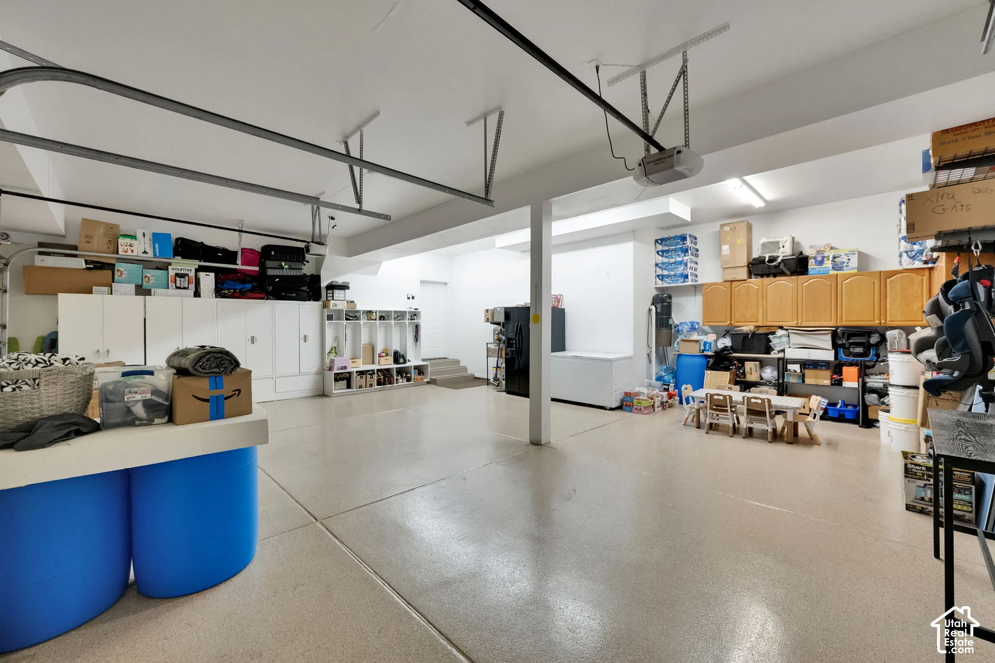 Spacious garage featuring a durable floor finish, extensive built-in cabinetry, and multiple overhead light fixtures