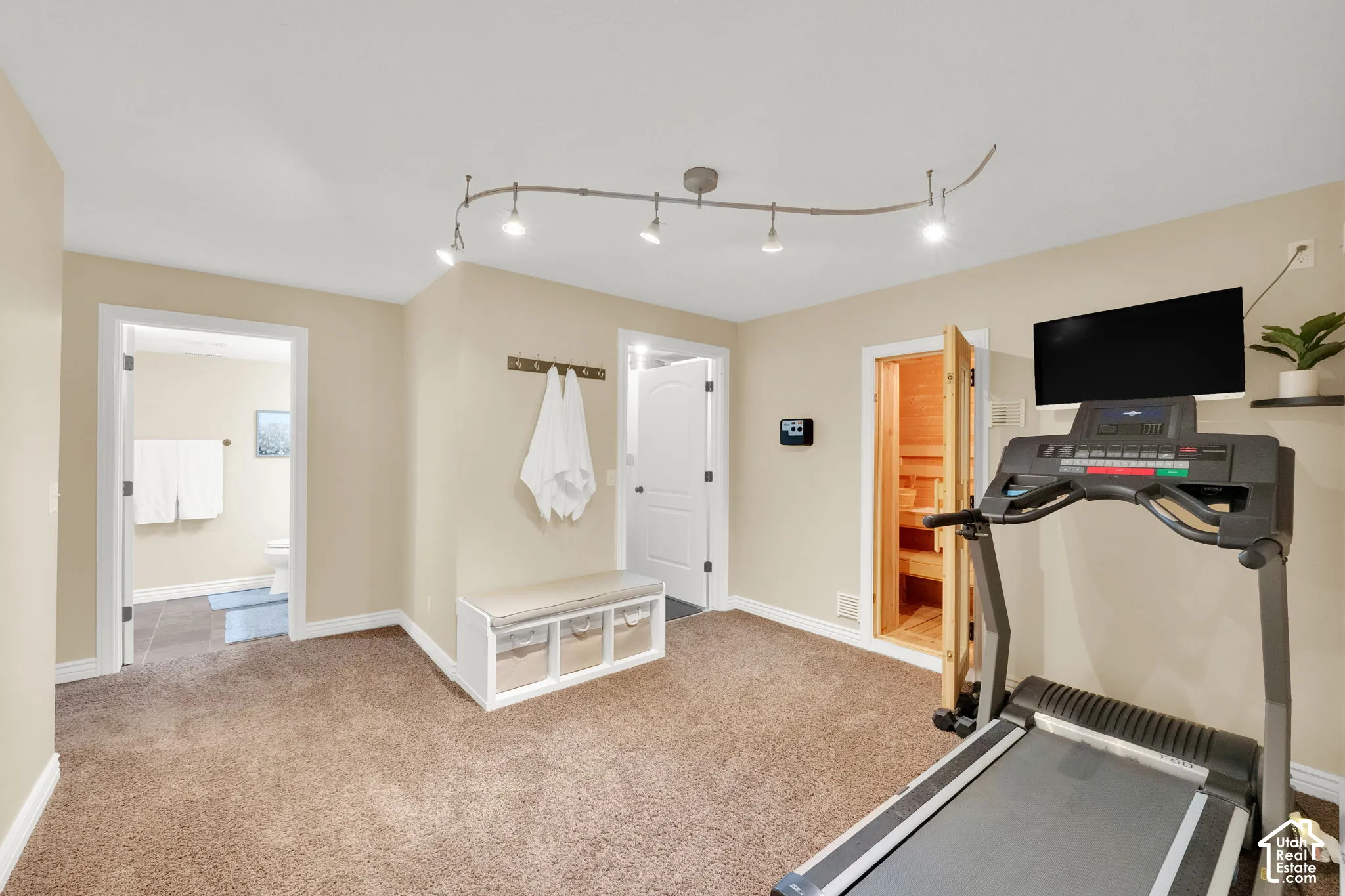 Carpeted flooring, recessed lighting, built-in sauna, and an adjacent bathroom with tile flooring