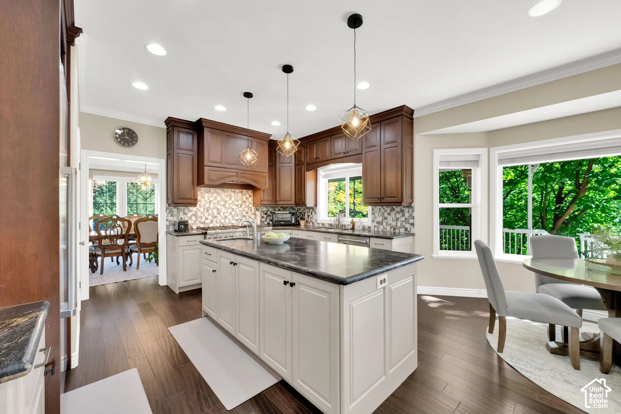 Spacious kitchen featuring an expansive center island, rich wood-finish flooring, recessed lighting, and a bay window