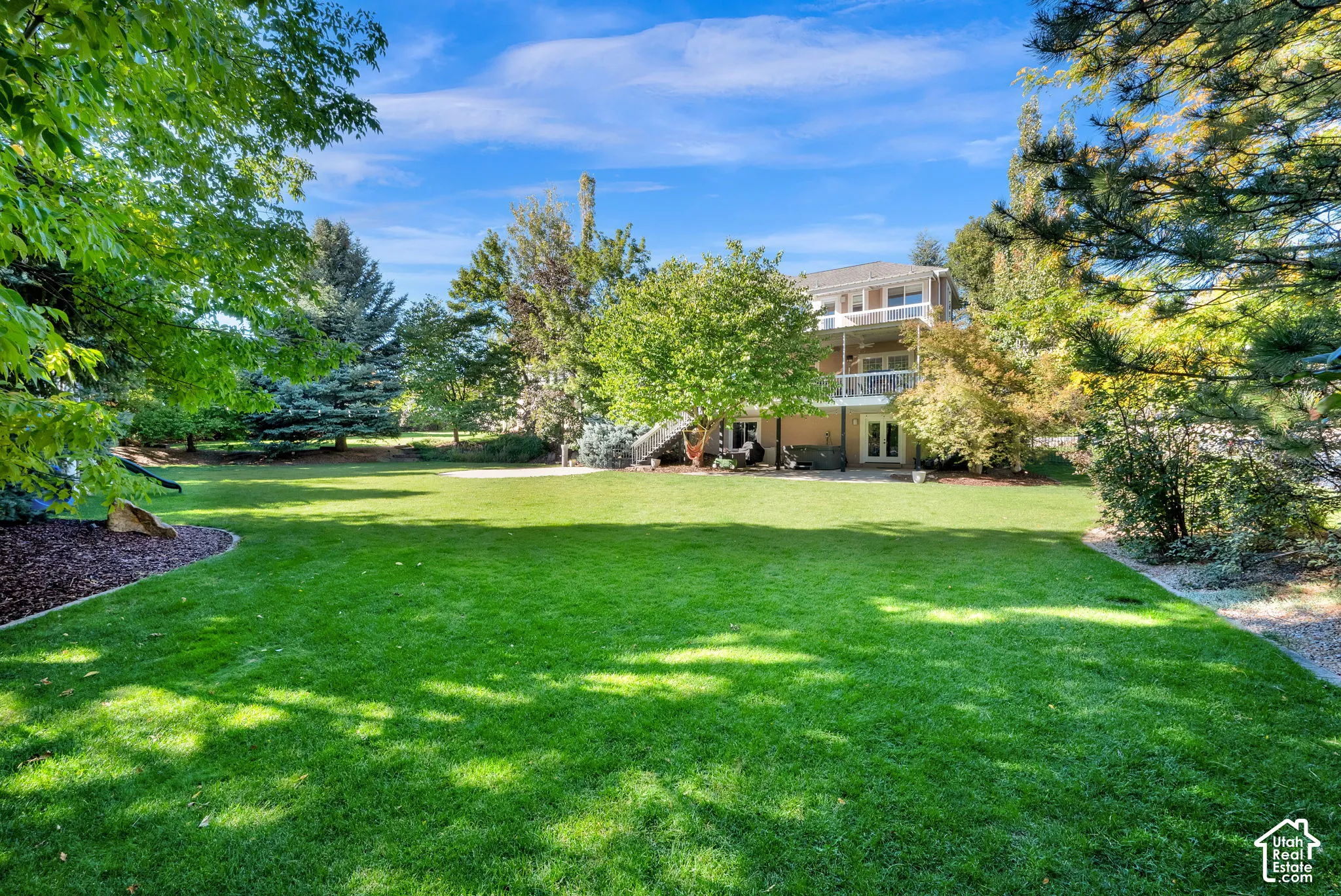 Expansive green lawn with mature trees and landscaping